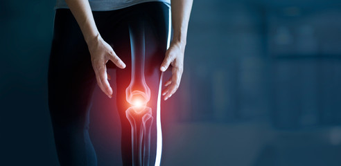 Woman suffering from pain in knee, Injury from workout and osteoarthritis, Tendon problems and Joint inflammation on dark background. - obrazy, fototapety, plakaty