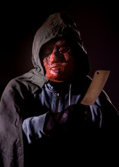 Scary killer in mask holding knife