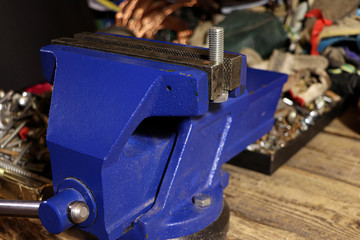 Blue vise on a wooden table. Bench tools. Vice.