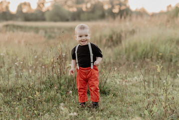 cute little baby boy smiling in autumn field