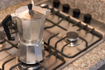 Moka pot, traditional Italian coffee maker put on the stove.
