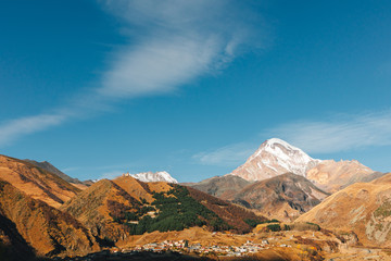 Stepantsminda, Kazbegi, Goergia. Cityscape of big rural town with mountain range of Kazbak.