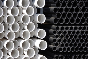 Close-up full frame sectional front view of construction supply stacks of plastic water pipes 