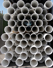 Close-up full frame sectional front view of construction supply stacks of plastic water pipes 