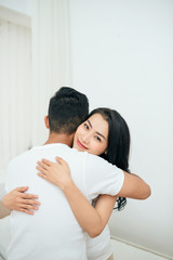 Young couple in the bedroom. Side view of unfaithful man and woman are cheating while hugging each other