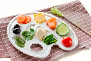 palette with colorful vegetables, fish and greens, creative food design, funny and healthy meal for kids.