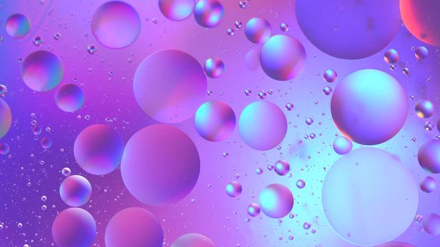 Oil drop in water macro. Neon purple pink ultraviolet and blue gradient. Holographic bubbles