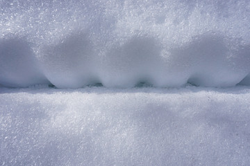 Detail of corrugated pattern imprinted in the snow for background with copy space