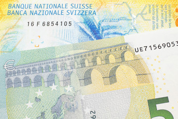 A yellow, ten Swiss franc note with a five euro bank note from the European Union's central bank