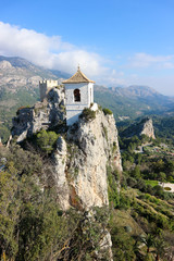 Fototapeta na wymiar View to castle watch tower and bell tower in Castell de guadalest with mountains on the background, Spain