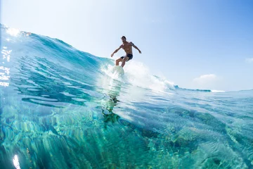 Abwaschbare Fototapete Surfer rides the glassy ocean wave in tropics © Dudarev Mikhail