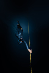 Woman freediver descends along the rope into the depth