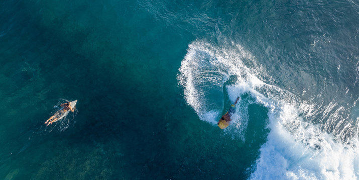 Surfers in the ocean, top to down aerial shot