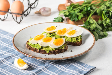 Toast with avocado and egg on rustic background