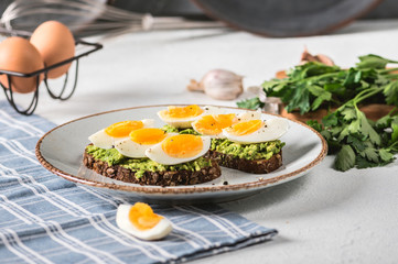 Toast with avocado and egg on rustic background