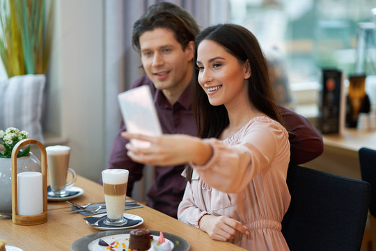 Young Couple taking selfie In Cafe