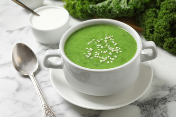 Tasty kale soup with sesame seeds on white marble table, closeup