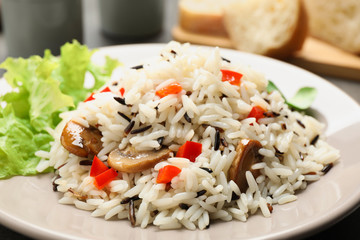 Delicious rice pilaf with mushrooms on plate, closeup