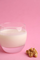 glass of walnut milk in color background