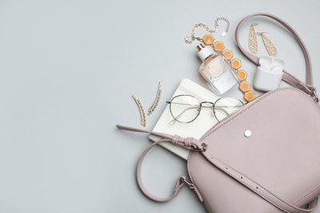 Stylish woman's bag with accessories on light grey background, flat lay. Space for text - obrazy, fototapety, plakaty