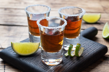 Glass with alcohol, salt and lime on a wooden background. Cognac whiskey tequila. The concept of the party. Selective focus Copy space.