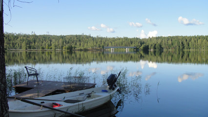 motor boat stands by the shore of a forest lake.