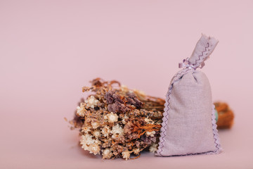 Dried lavender in a sack isolated on pink background. Bouquet of lavender in sack on rose...