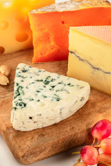 Cheese platter. Blue cheese, goat cheese etc, a close-up on a wooden board