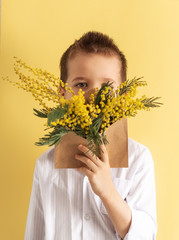 Cute little boy holding a bouquet of flowers. Tulips. Mothers Day. International Women's Day....