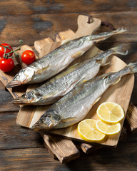 Smoked or dried smelt fish on a wooden Board on a brown wooden table. Top view with space for text