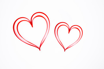 two hearts made of red silk or satin ribbon isolated on white background, decoration for gift, greeting card