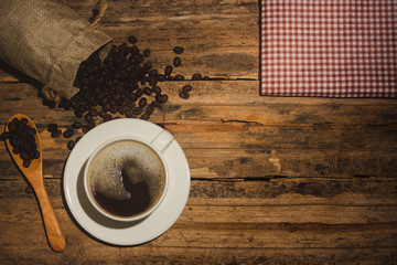 Coffee cups and coffee beans roasted on a wooden table Divide space for text
