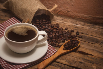 Coffee cups and coffee beans roasted on a wooden table Divide space for text