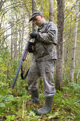 hunter loads a gun in the aspen forest