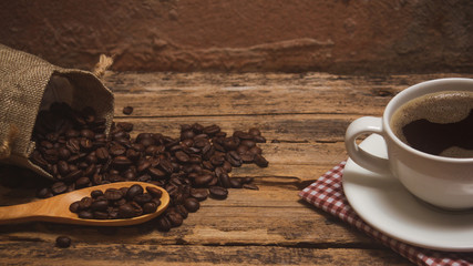 Coffee cups and coffee beans roasted on a wooden table Divide space for text