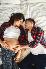 Naklejka premium Portrait of a young couple waiting for a baby, pregnant couple posing for the camera.