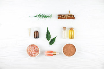 Homemade spa cosmetic set with salt and oil on white wooden background. Copy space. Flat lay style.