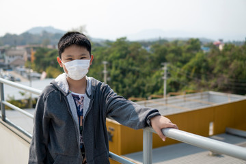 Asian boy wearing mouth mask against air pollution.