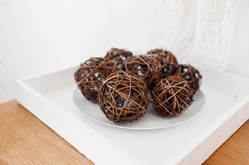 Decorated circles woven from branches, nests on a white plate in the interior. Accessories for a BOHO-style room