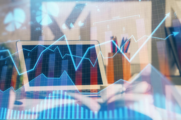 Financial graph colorful drawing and table with computer on background. Multi exposure. Concept of international markets.