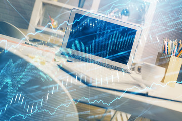 Obraz premium Financial graph colorful drawing and table with computer on background. Double exposure. Concept of international markets.