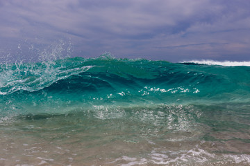 Obraz na płótnie Canvas Fresh ocean wave breaking under stormy sky