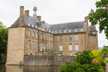 The castle of Flers, now a museum (Normandy, Orne, France). Beautiful medieval architecture. Wide-angle shot of this historical monument. Surrounded by a moat. Cloudy day. 