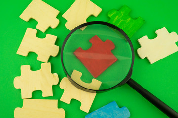 Jigsaw puzzle pieces with magnifying glass