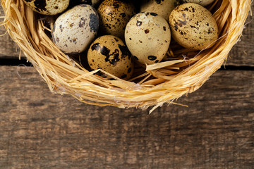 Naklejka na ściany i meble Quail eggs in nest on wooden table