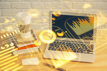 Computer on desktop in office with technology theme hologram. Multi exposure. Tech concept.