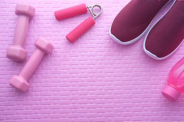 top view of dumbbell and shoe on exercise mat.
