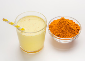 Turmeric milk with cinnamon and turmeric on white