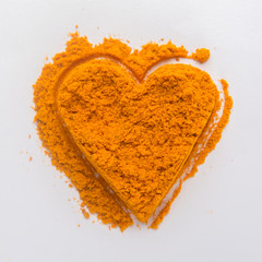 Turmeric powder in the shape of a heart Isolated on white
