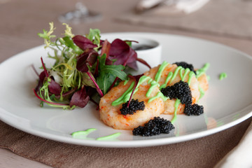 Crab cakes with salad mix, teriyaki sauce, seaweed caviar